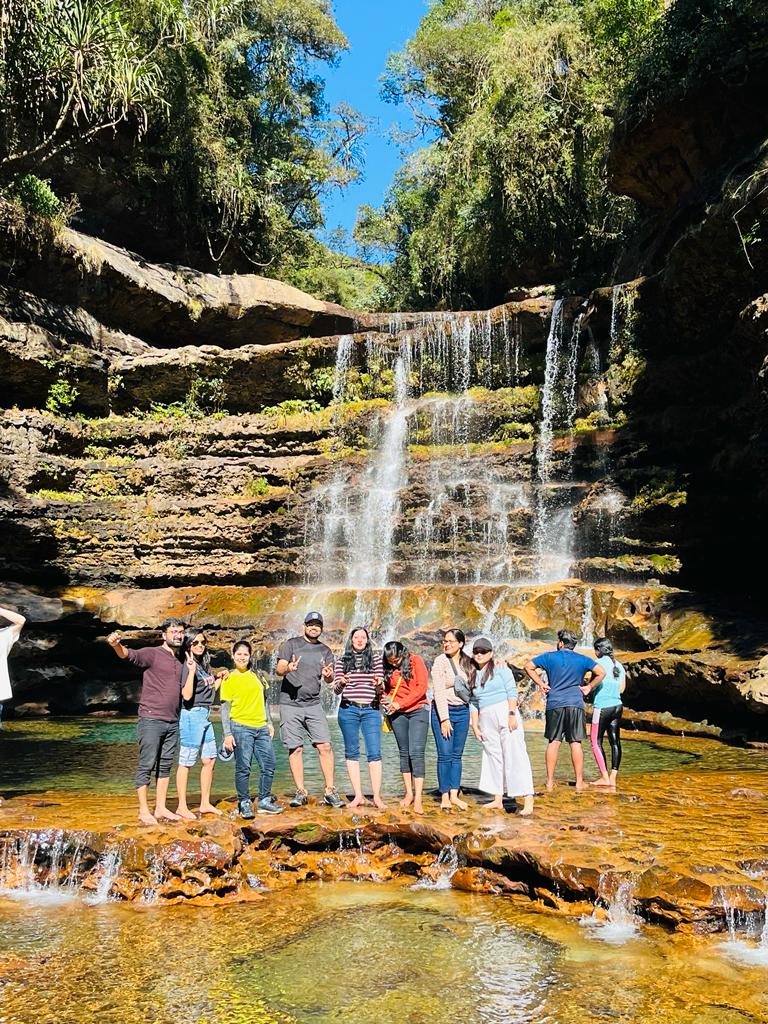 Group of travellers in front of a tiered waterfall in Meghalaya