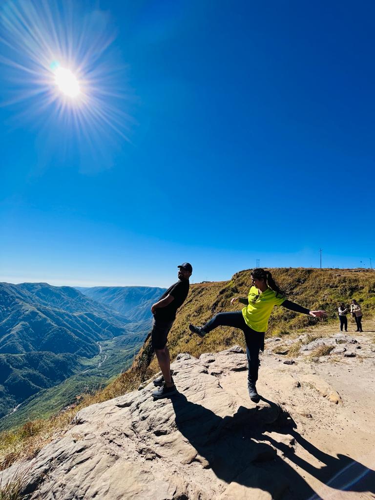 Two travellers enjoying a clifftop view over Meghalaya's valleys